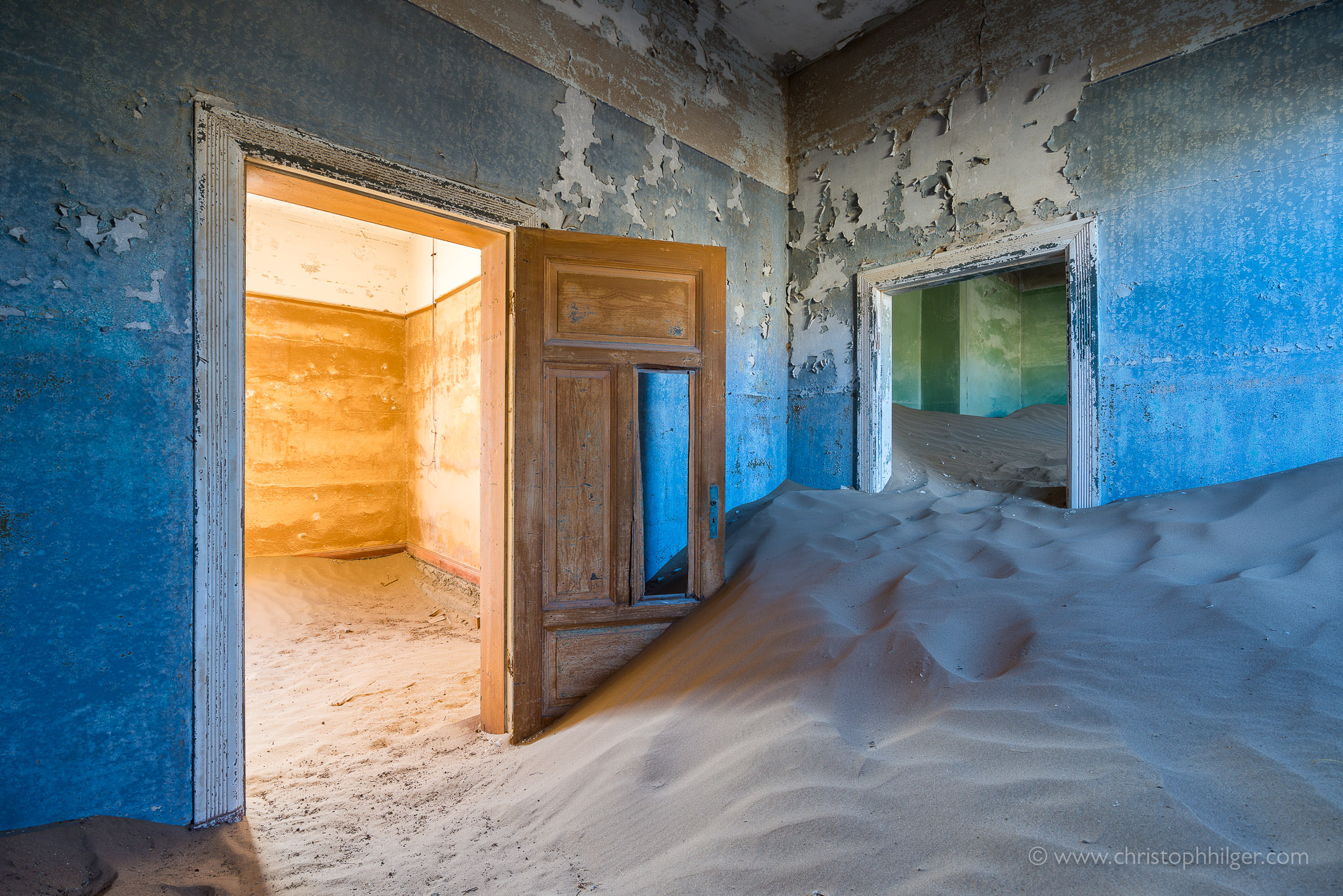 Bunte Räume und Sand in verlassenem Haus in Kolmanskop, Namibia