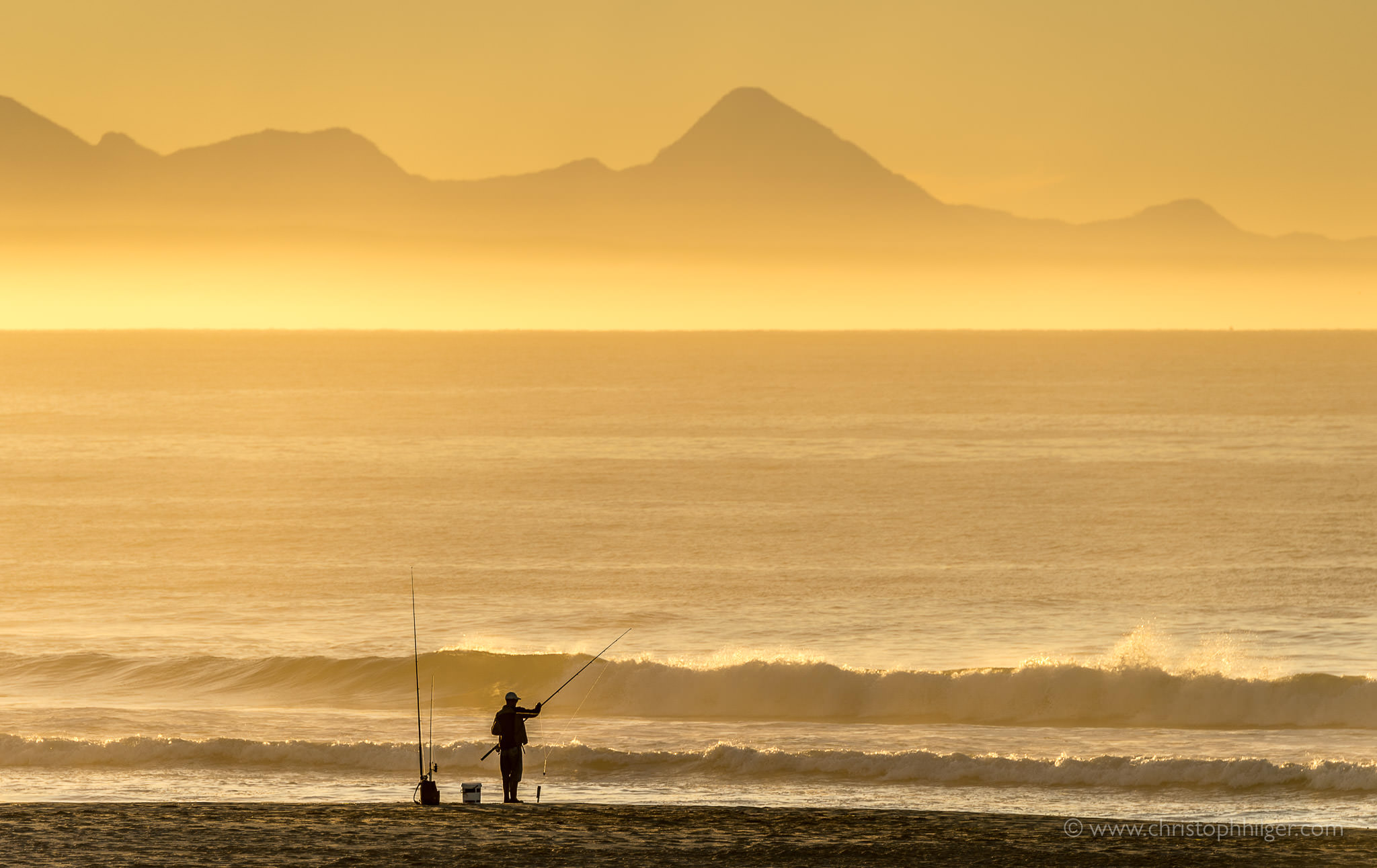 Angler bei Sonnenaufgang in Plettenberg Bay, Südafrika